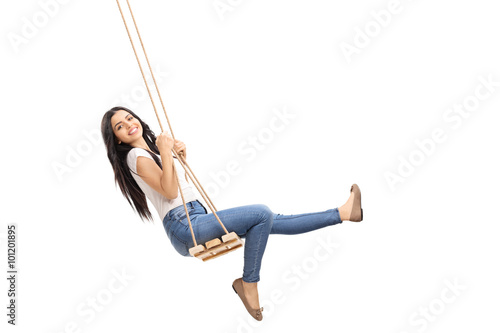 Young carefree girl swinging on a swing photo