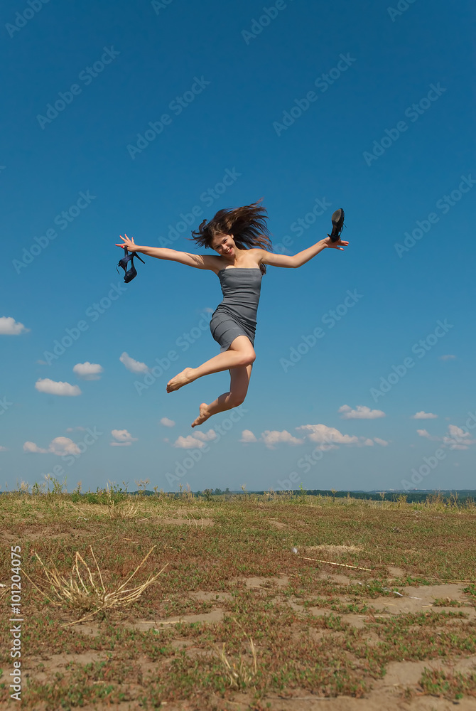 Barefooted girl jumping with her shoes