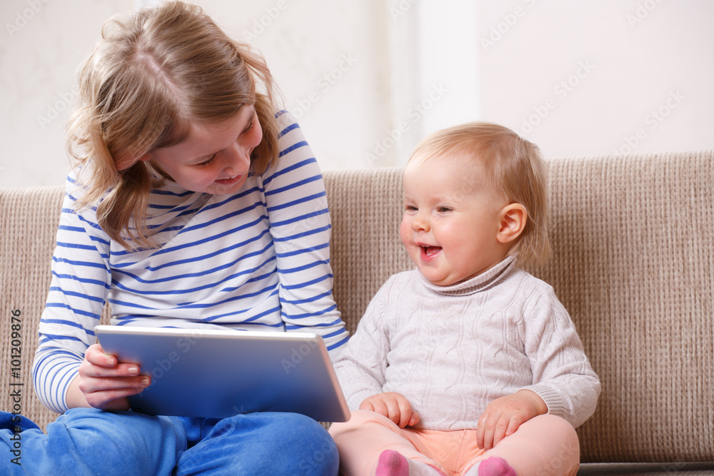 Two sisters watching tablet PC Two sisters watching tablet PC