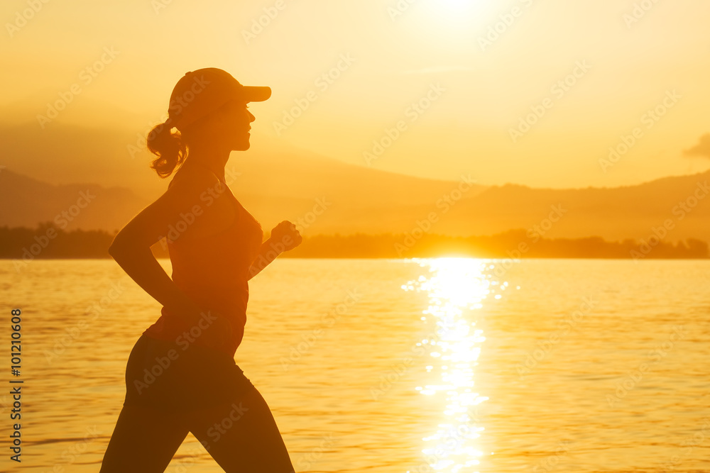 Woman running on the beach at sunset.