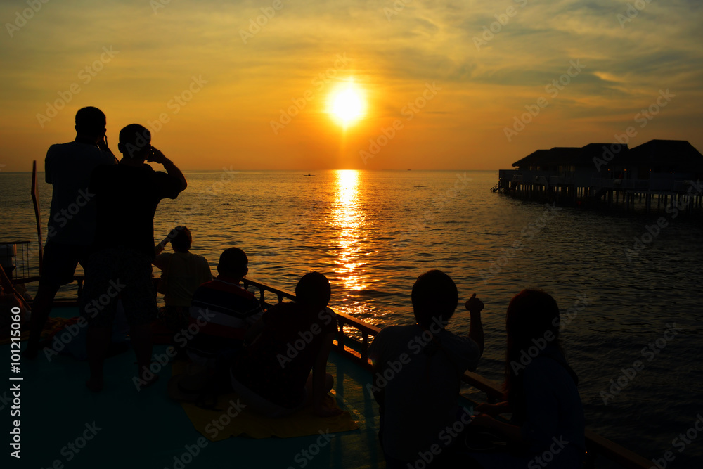 Silhouette of couple lovers and tourist watching the sun setting