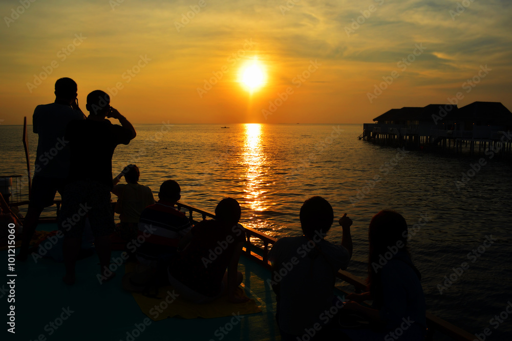 Silhouette of couple lovers and tourist watching the sun setting Silhouette of couple lovers and tourist watching the sun setting
