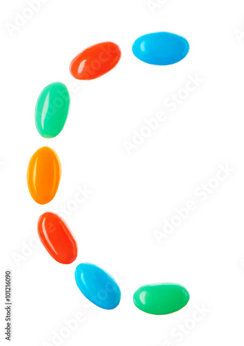 C letter made of multicolored candies isolated on white