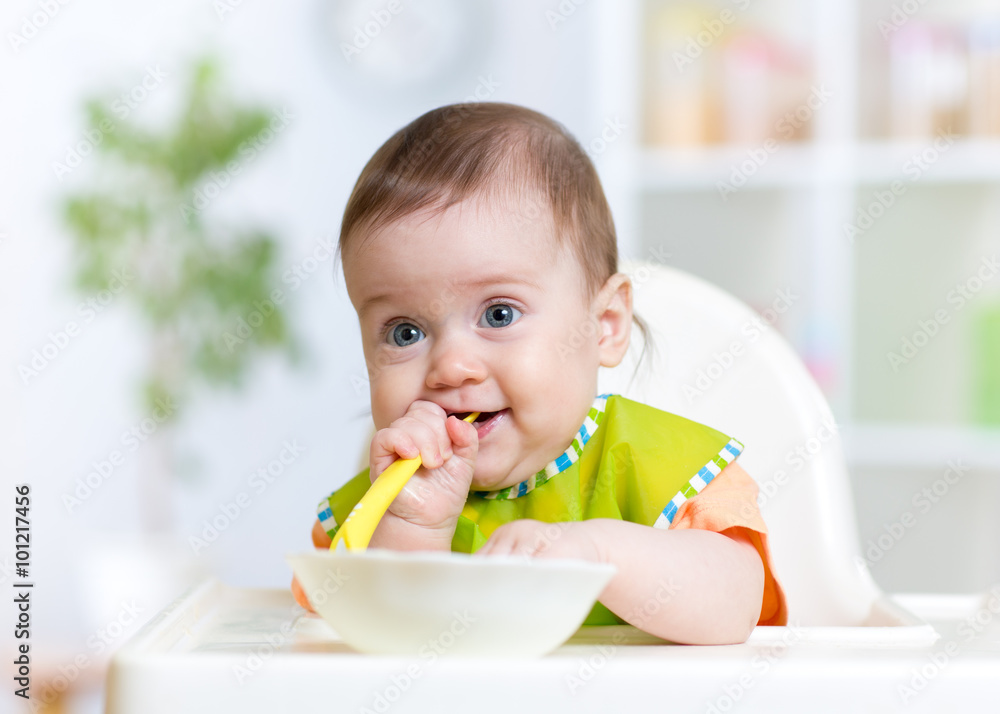 baby child sitting in chair with a spoon baby child sitting in chair with a spoon