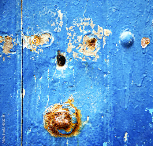 stripped paint in the blue wood door and rusty nail photo