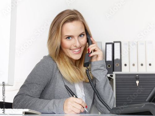 Female office assistant has a call