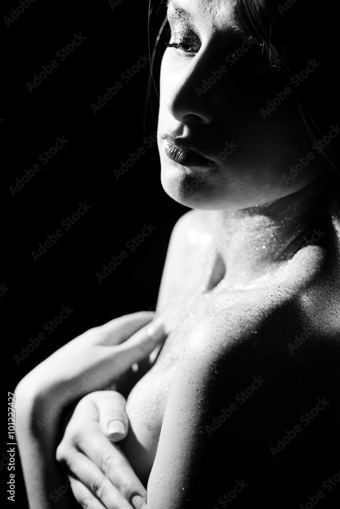 Black and white photography of beautiful female sensually hiding breasts