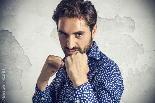 Aggressive young businessman showing fists