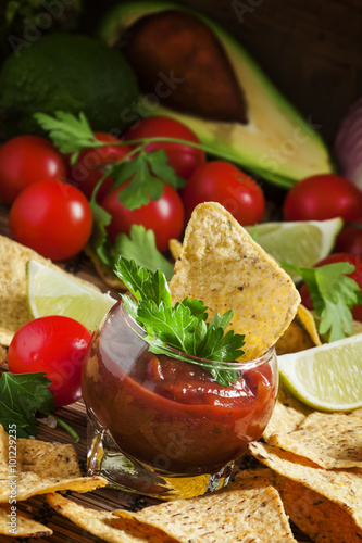 Unhealthy food: Mexican nachos with spicy tomato sauce and lime,