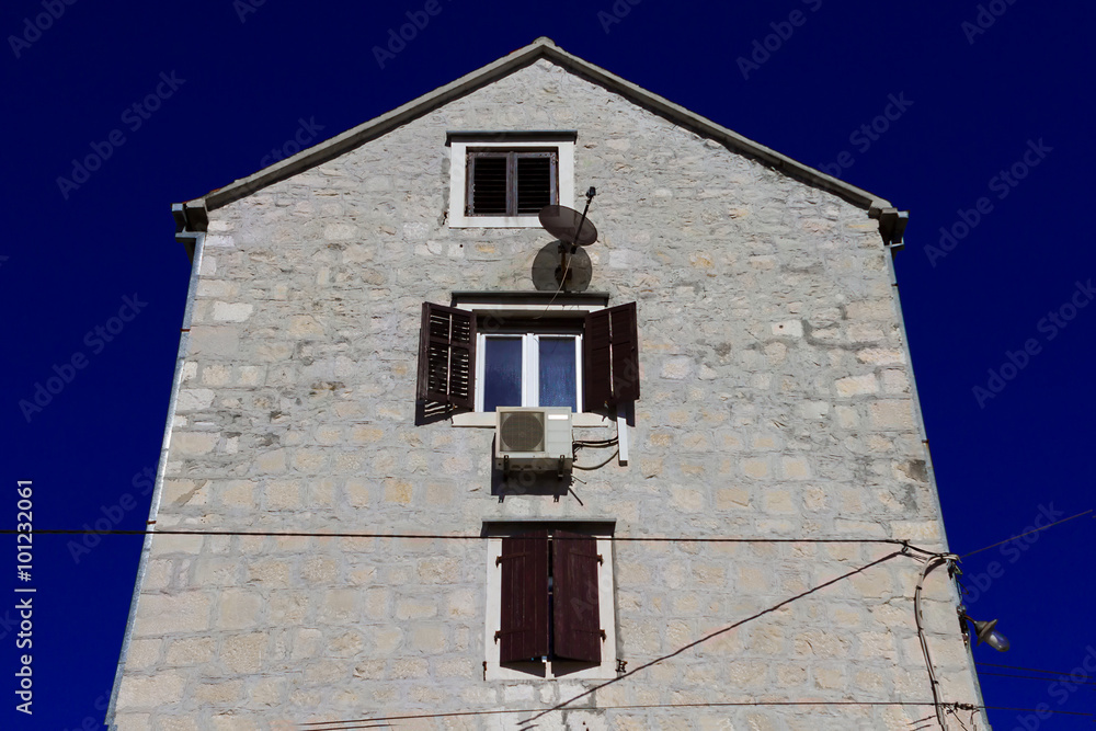 Obraz premium Brickwork house with open window against blue sky.