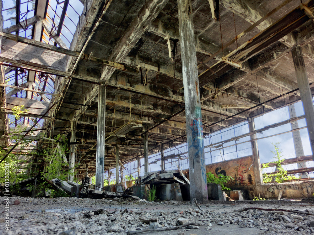 Abandoned factory with broken windows and growing weeds - landscape photo