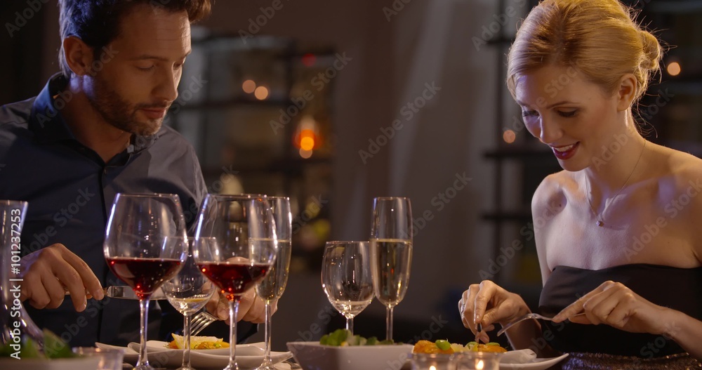 Beautiful elegant couple have dinner with salmon in a restaurant in the evening in slow motion (in realtime at 60 fps) Beautiful elegant couple have dinner with salmon in a restaurant in the evening in slow motion (in realtime at 60 fps)