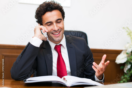 Cheerful man in office answering the phone