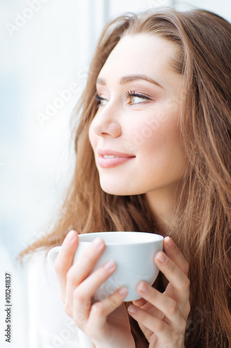 Charming happy woman drinking coffe
