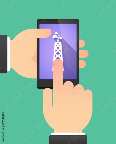 Hands using a phone showing an oil tower