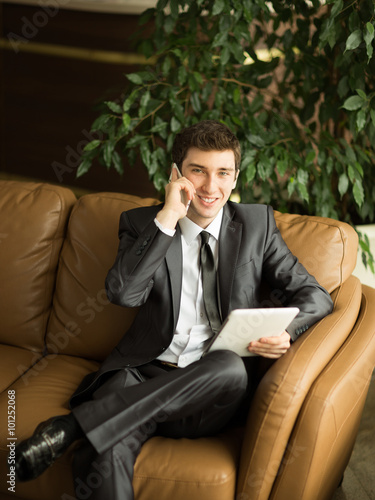 Relaxed businessman sitting in front of the Windows of the offic