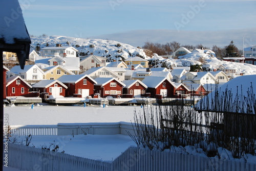 Boathouses covered in snow on the west coast of Sweden on a sunny day in the winter