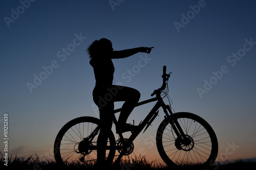 Mountain biker girl silhouette in beautiful sunset
