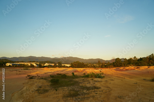 Tropical laterite soil or red earth background. Red mars seamless sand background.with blue sky.