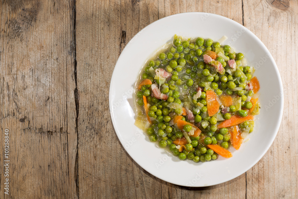 Petit pois a la Francaise looking down on plate. A traditional popular French dish prepared with garden peas, carrots, bacon, leek, onion and braised lettuce
Petit pois a la Francaise looking down on plate. A traditional popular French dish prepared with garden peas, carrots, bacon, leek, onion and braised lettuce