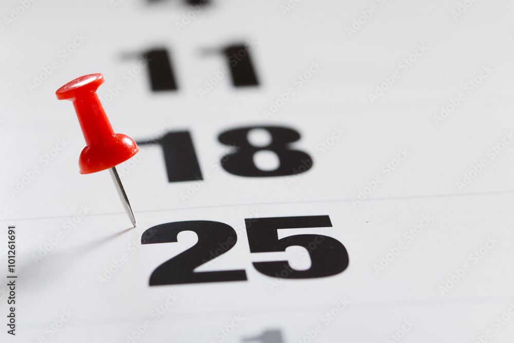Pin pushed on a calendar concept for an important day. Pin pushed on a calendar concept for an important day.