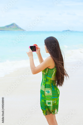 Beautiful teen girl in Hawaii holding camera taking pictures