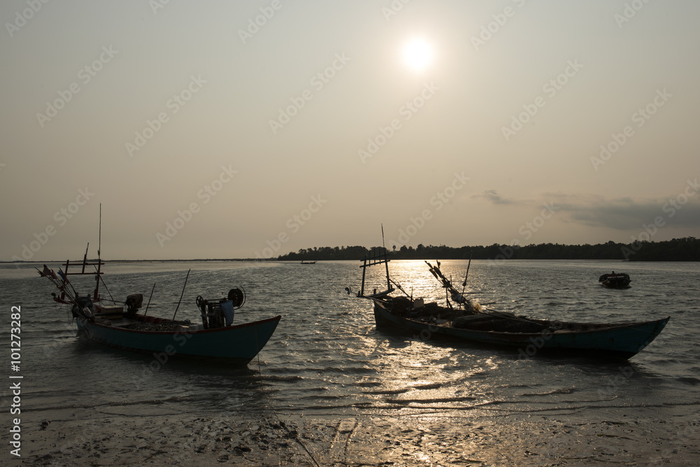 Atardecer en la costa de Kampot, con silueta de barcos de pescadores. Camboya