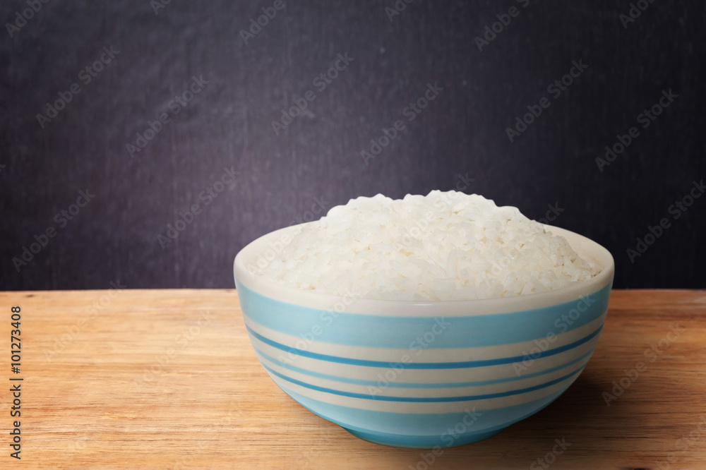 White rice in bowl on dark wooden background