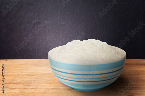 White rice in bowl on dark wooden background