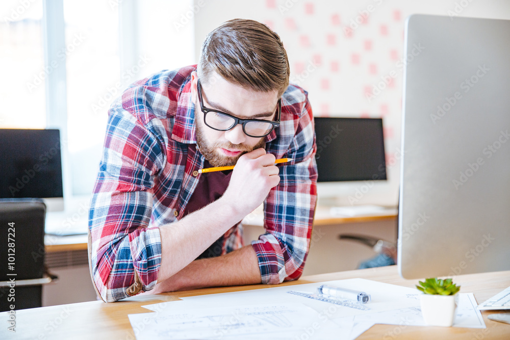Thoughtful creative man designing project and making blueprint Thoughtful creative man designing project and making blueprint
