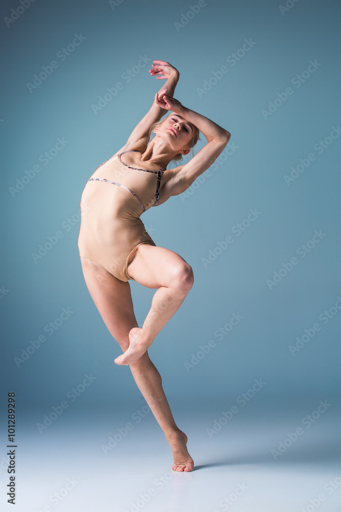 Fototapeta premium Young beautiful modern style dancer jumping on a studio background