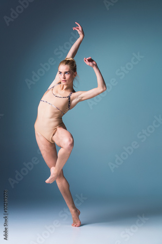 Fototapeta Naklejka Na Ścianę i Meble -  Young beautiful modern style dancer jumping on a studio background