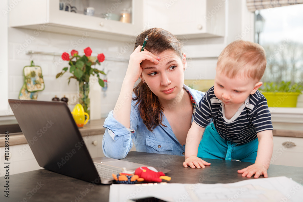 Young mother working with her baby Young mother working with her baby