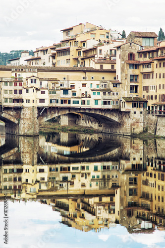 Ponte Vecchio and historic buildings are mirrored in the Arno