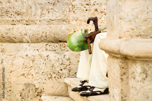 Photography Detail of unrecognizable person with cuban cigar sitting on stairs at Havana old