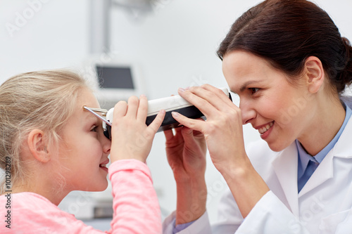 optician with pupilometer and patient at eye clinic photo