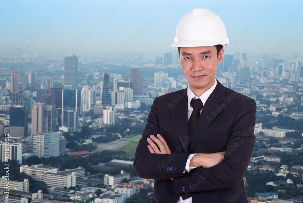 engineer in helmet with arms crossed, city background engineer in helmet with arms crossed, city background