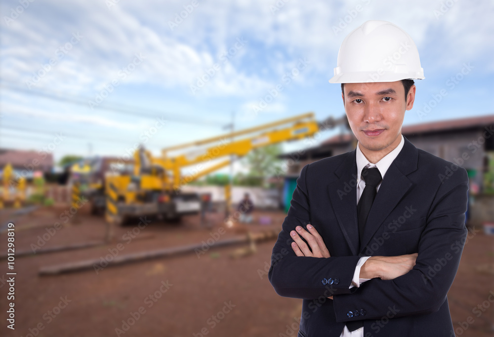 engineer in helmet with arms crossed, construction site backgro engineer in helmet with arms crossed, construction site backgro