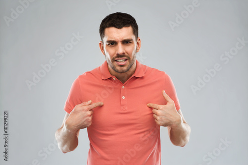 Photos angry man pointing finger to himself over gray
