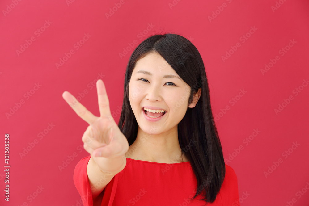 ピースする若い女性・赤バック ピースする若い女性・赤バック