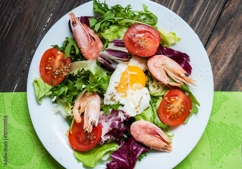 Healthy Shrimp and Arugula Salad with Tomatoes on a wooden table