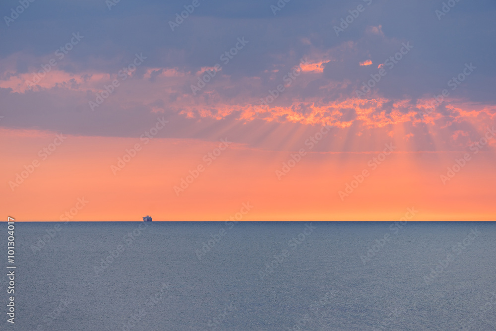 Fototapeta premium Cruise ship on a open sea during a sunset.