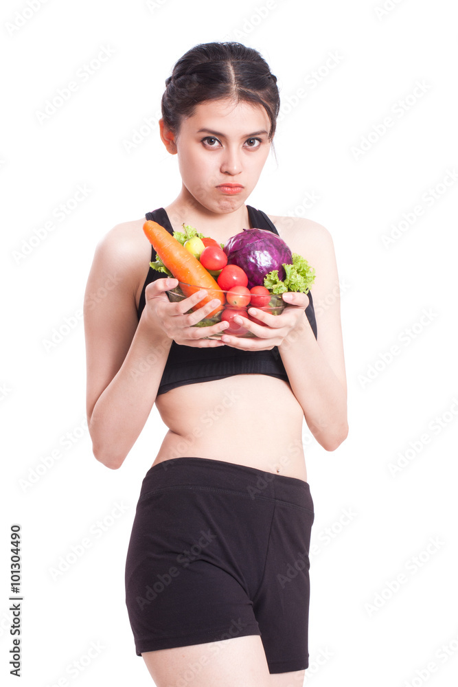 young woman with vegetables with a expression of disgust and boredom young woman with vegetables with a expression of disgust and boredom