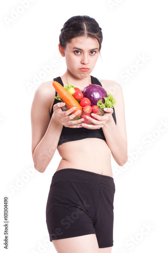 young woman with vegetables with a expression of disgust and boredom © japhoto