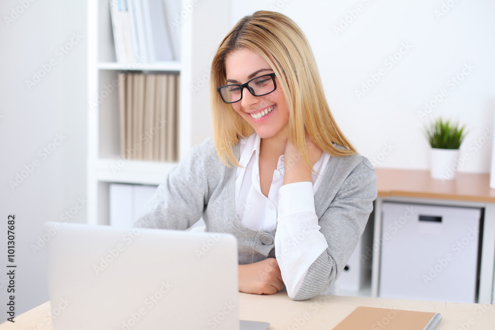 Portrait of young business woman sitting at the desk on office background Portrait of young business woman sitting at the desk on office background