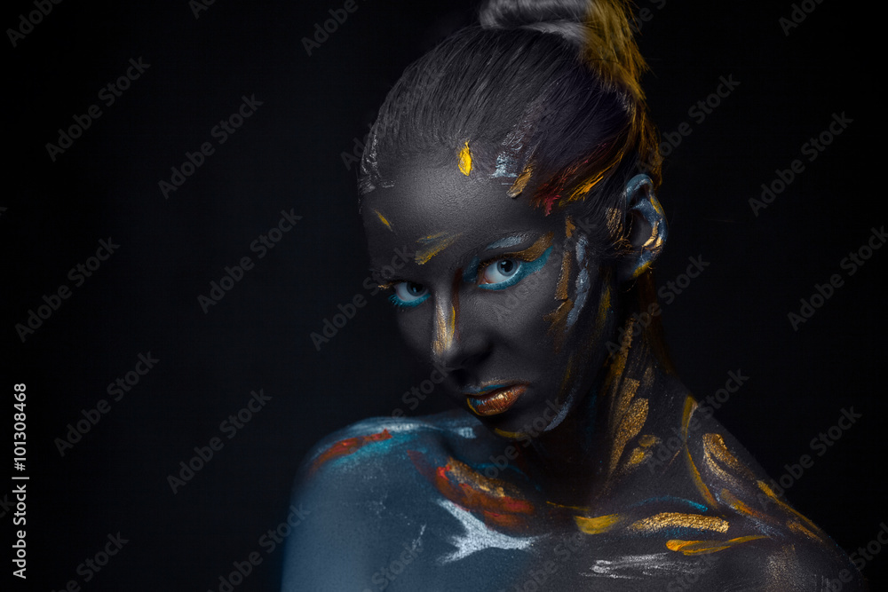 Portrait of a young woman who is posing covered with black paint Portrait of a young woman who is posing covered with black paint