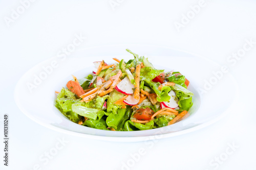 Vegetable salad with radishes, carrots, onions and tomatoes on a white background