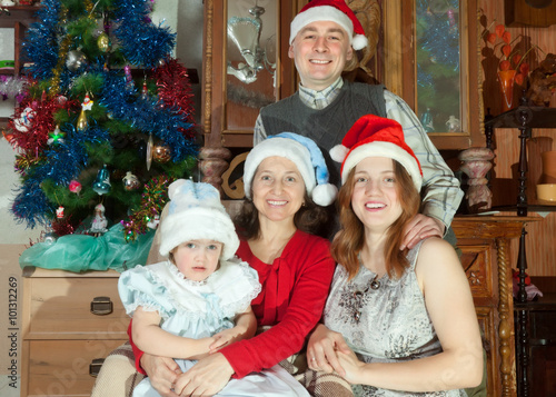 Foto Happy family  in santa hats celebrating Christmas