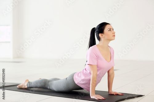 Fototapeta Naklejka Na Ścianę i Meble -  Beautiful healthy woman does yoga exercises in the gym, close up