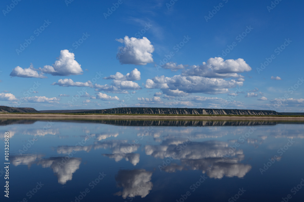 Φωτογραφία Reflection of clouds in the river and the distant shore